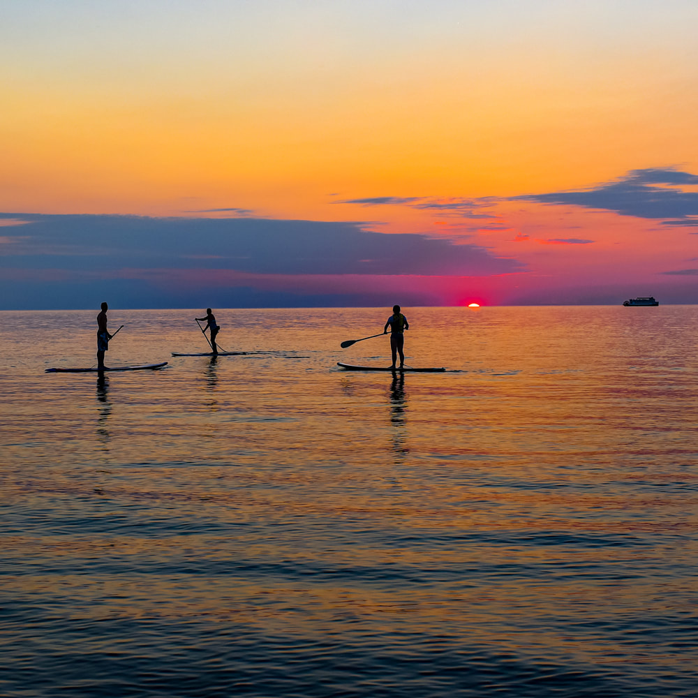 Paddleboarders at sunset