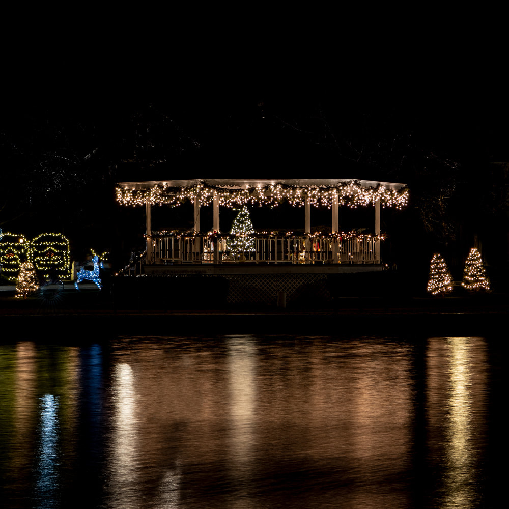 The Wicks Park gazebo lit at night and reflected in the river