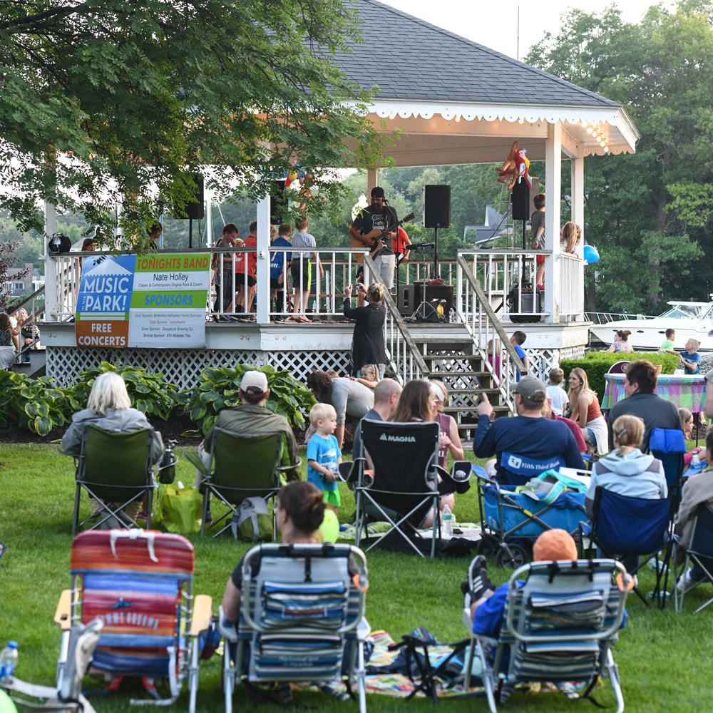 A crowd on lawn chairs at a Wicks Park concert