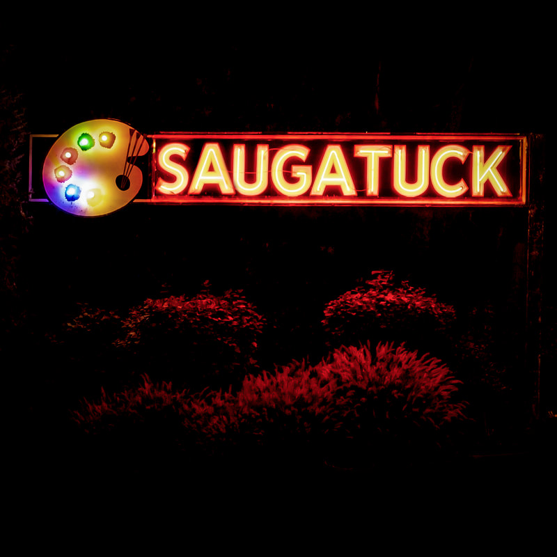 The glowing Saugatuck sign downtown at night