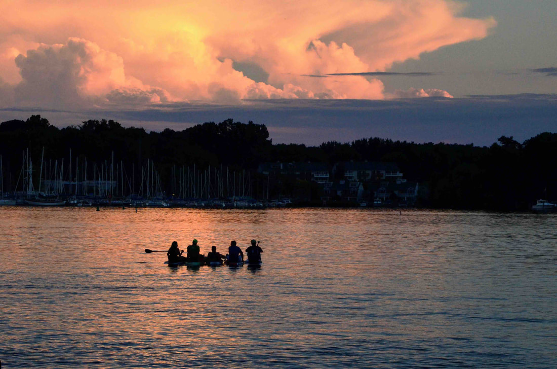 Kayakers on the Kalamazoo River at sunset