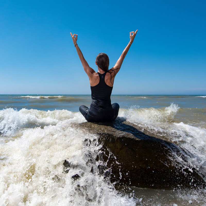 People practicing yoga at the edge of Lake Michigan